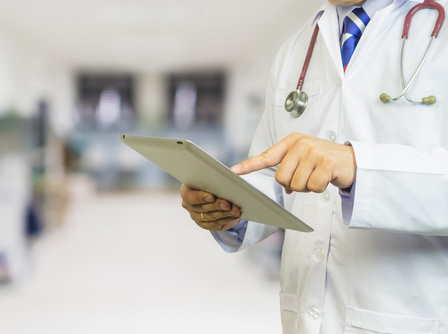 Picture of a male Physician pointing at a tablet.