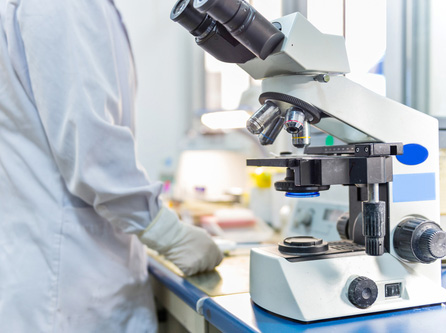 Picture of a microscope sitting on top of a table in a Lab.