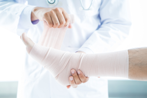 Picture of a Physician wrapping a patients leg with a bandage.